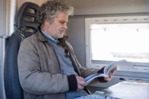 man met boek op trein