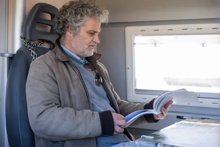 man met boek op trein